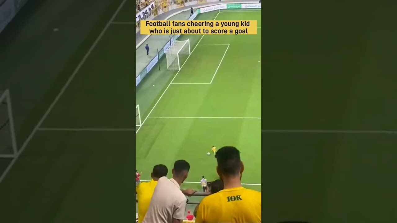 Football fans cheering a young kid who is just about to score a goal.